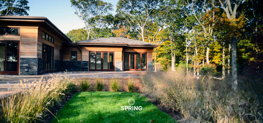 Eco-friendly modern home by Spring Architecture + Design with panoramic glass windows and natural exterior finishes in Sag Harbor, NY.